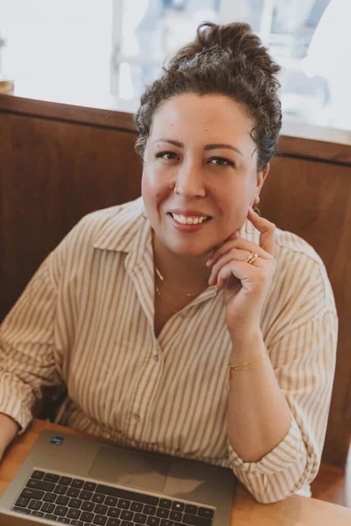 Kim Faust seated at a table and smiling toward the camera.